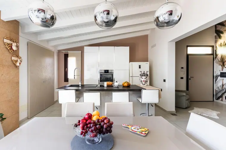 Cucina bianca con isola e zona pranzo